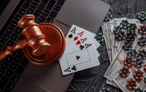 Save Download Preview Online gambling and justice theme, cards, playing chips and judge wooden gavel on laptop keyboard